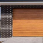 A premium timber-look sectional garage door installed on a modern dark brick residential home in Shepparton.